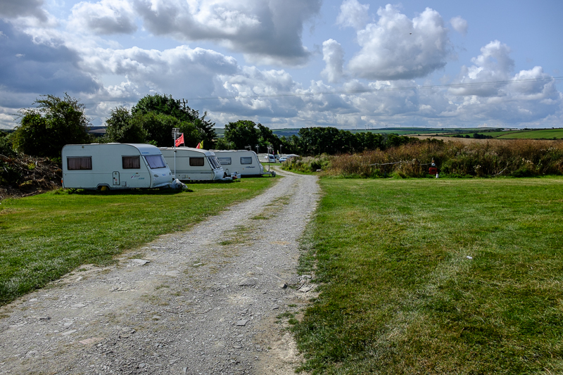 Touring caravans on grassy pitches beside Ponderosa's rural driveway